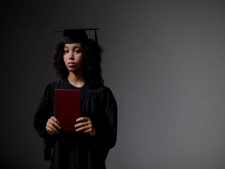 Woman in Academic Dress Holding Red Book