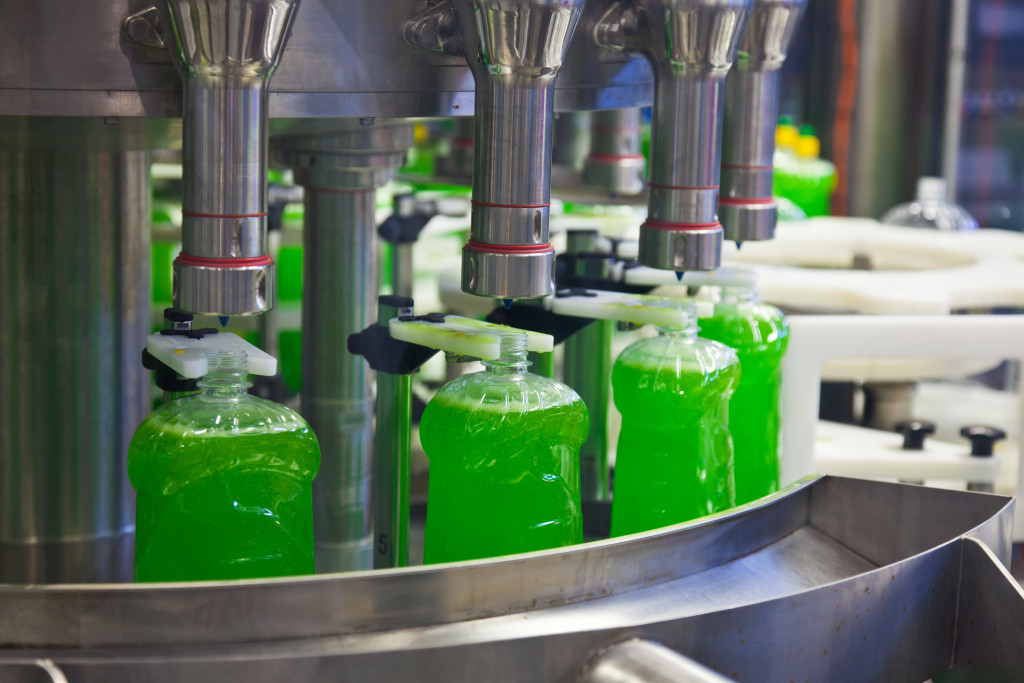 machine dispensing liquid on bottles