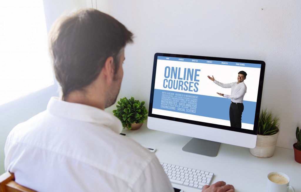 a male instruction in front of a pc with online courses